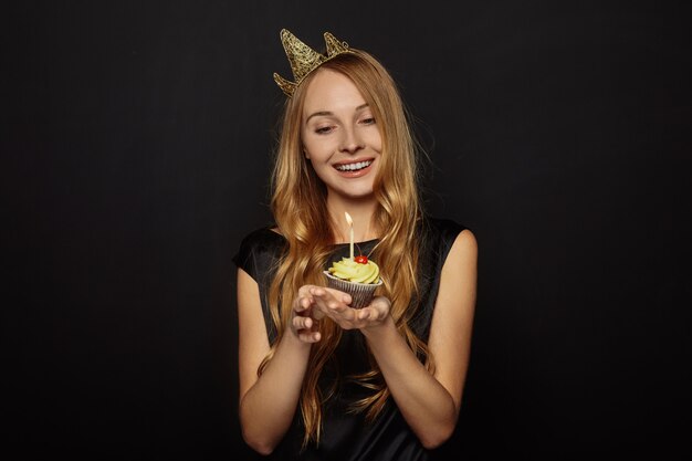 Attractive girl with a crown and cupcake