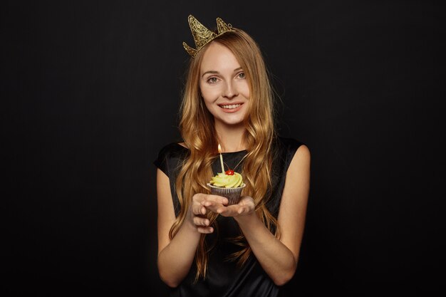 Attractive girl with a crown and cupcake