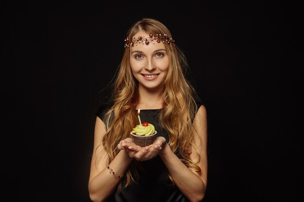 Attractive girl with a crown and cupcake