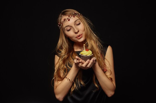 Attractive girl with a crown and cupcake