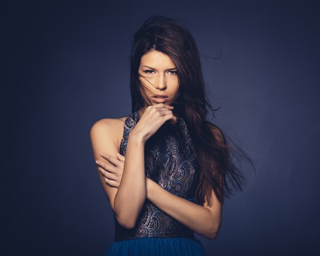 Attractive girl with flying hair posing in studio