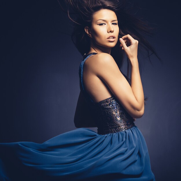 Attractive girl with flying hair posing in studio