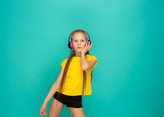 The attractive girl with headphones on blue