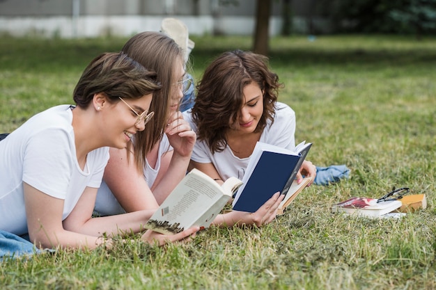 Attractive girls friends reading together in summer