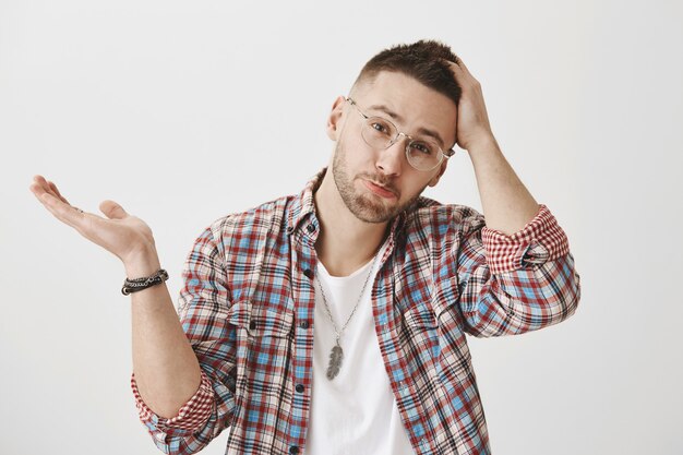 Attractive gloomy young guy with glasses posing