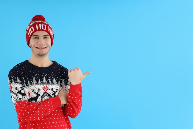 Attractive guy in christmas sweater on blue background