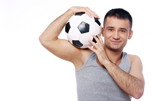 Привлекательный парень держит футбольный мяч