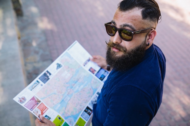Free photo attractive guy posing with a map