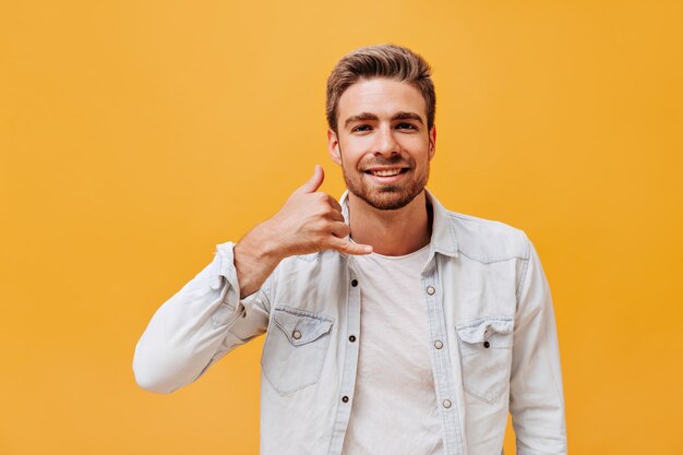 Attractive guy with ginger beard in white modern shirt and light plaid tshirt looking into camera on isolated backdrop