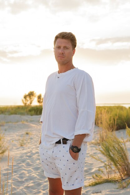 Attractive handsome european man standing on the beach.