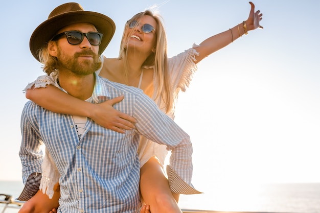 Attractive happy couple laughing traveling in summer by sea