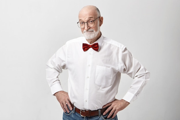 Attractive happy elderly Caucasian man in good mood posing isolated in studio