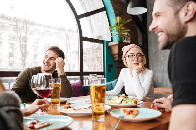 Attractive happy friends sitting in cafe