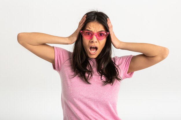 ピンクのTシャツで魅力的な幸せな面白い驚きの感情的な女性は、前方に驚いたショックを受けた顔の表情を分離