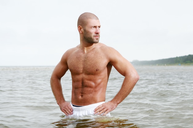 Foto gratuita uomo attraente e felice sulla spiaggia