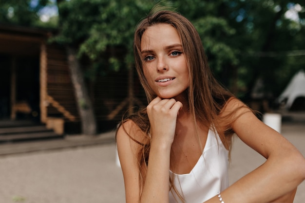 Attractive happy woman wearing white t-shirt at the beach in sunny warm day