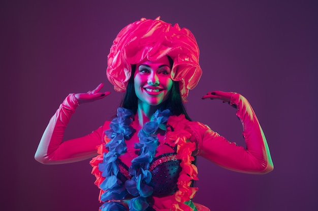 Attractive hawaiian brunette model on purple studio wall in neon light