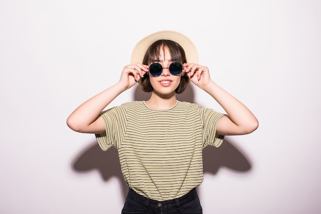 Free photo attractive hipster fashion teen girl in hat, sunglasses in white wall