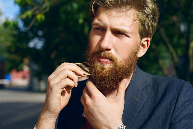 Attractive man combs beard hair