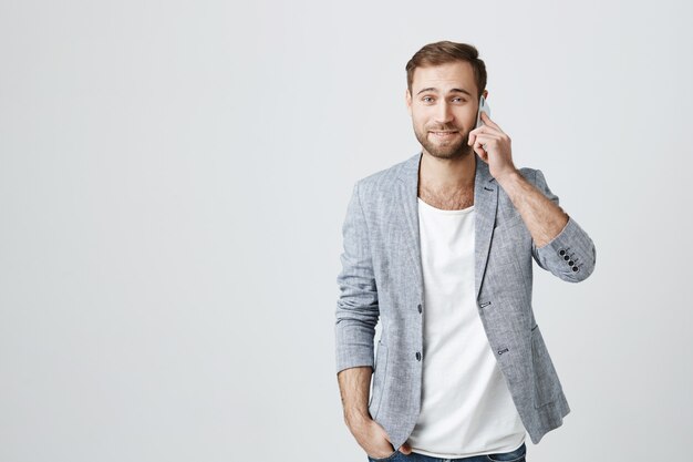 Attractive man in jacket having phone conversation