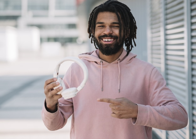 Free photo attractive man pointing at headphones