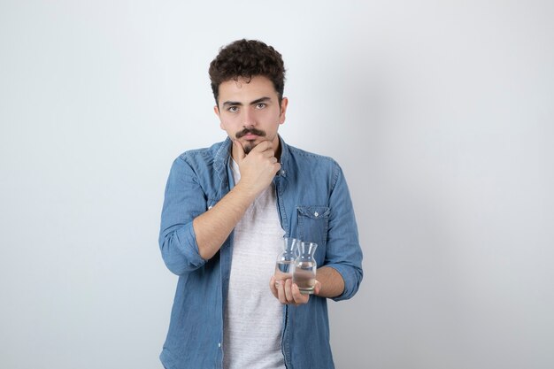 an attractive man standing and holding glass jars