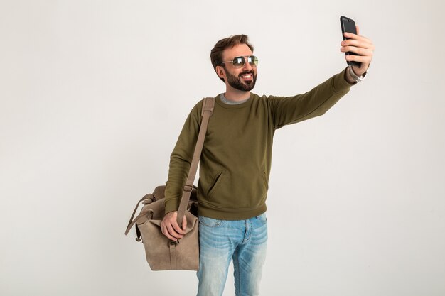 Attractive man traveler with bag isolated taking selfie photo