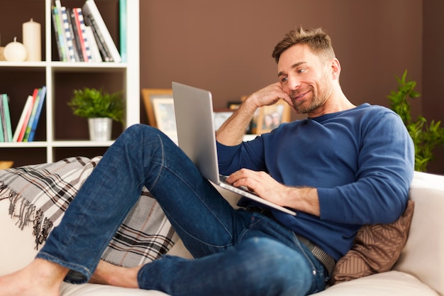 Attractive man using laptop at home