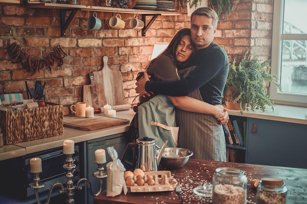 Attractive mature man is spending his morning with his wife at the kitchen.