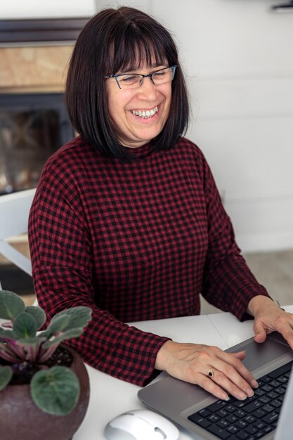 Free photo attractive middleaged woman working on a laptop while sitting at a table