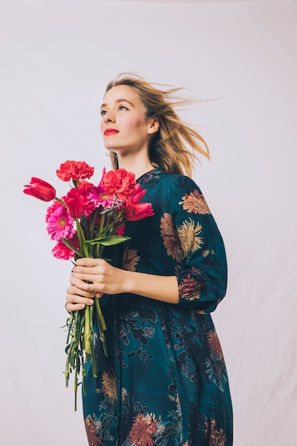 Attractive positive sensual woman with bouquet of flowers