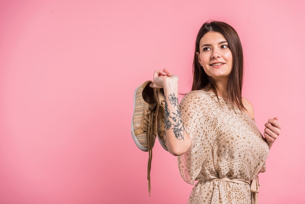 Free photo attractive positive woman holding shoes