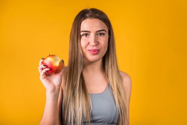 Attractive positive woman with bitten fruit