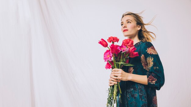 Attractive positive woman with bouquet of flowers