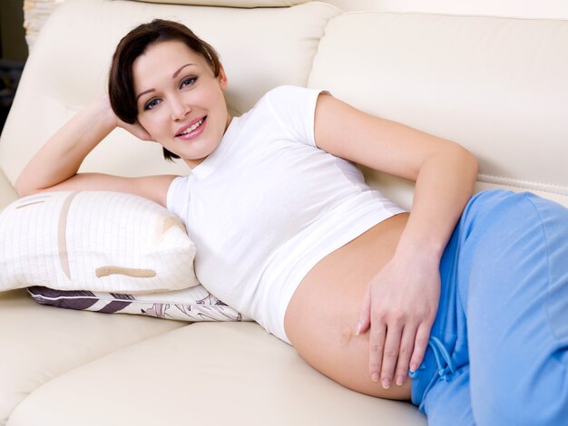 Привлекательная беременная женщина на девять месяцев отдыха дома