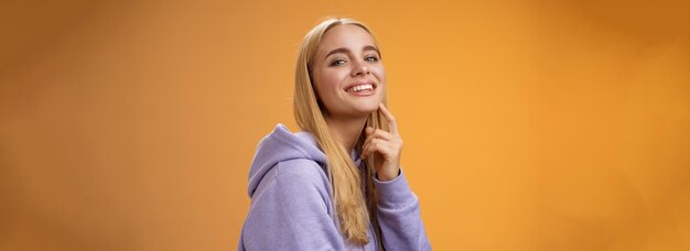 Attractive sassy selfassured caucasian blond female in purple hoodie turning camera touching chin ch