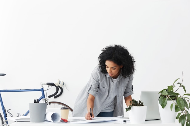 Free photo attractive serious young african american woman engineer drawing sketch