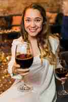 Free photo attractive smiling woman offering a glass of wine