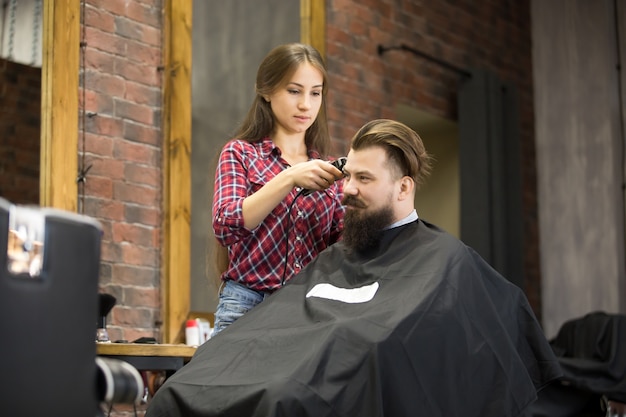 Free photo attractive smiling young man in barbershop