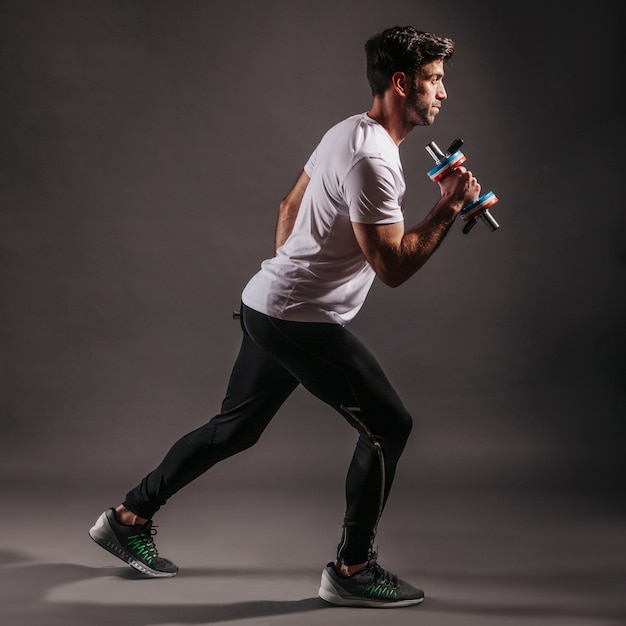 Attractive sportsman lifting dumbbells