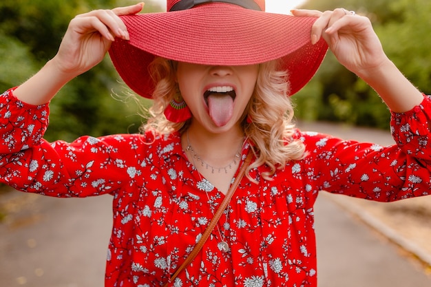 Free photo attractive stylish blond smiling woman in straw red hat and blouse summer fashion outfit  funny