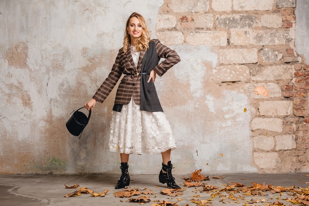 무료 사진 거리에서 벽에 걸어 체크 무늬 재킷에 매력적인 세련된 금발의 여자