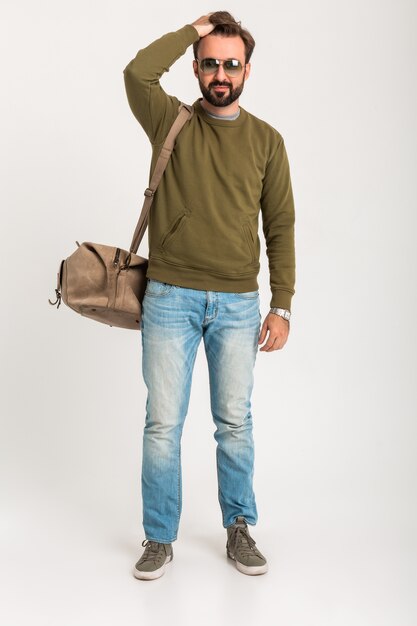 Attractive stylish man traveler isolated standing with bag handsome dressed in jeans and sweatshot full heigth