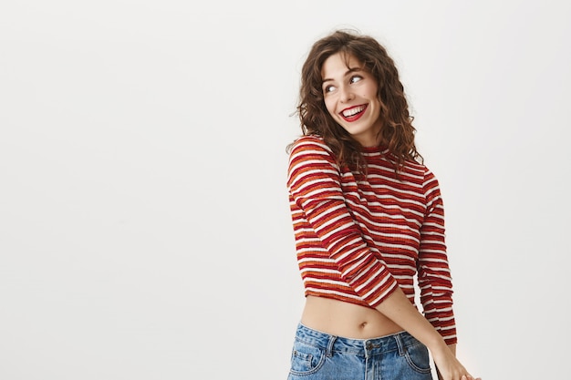 Free photo attractive stylish woman looking left and smiling pleased