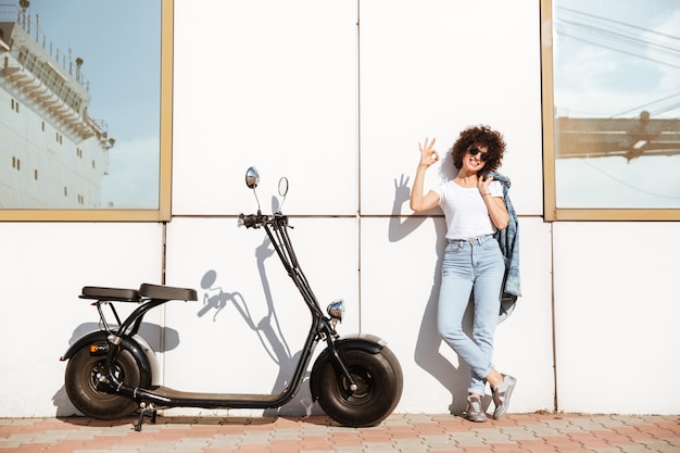 Foto gratuita donna alla moda attraente nella posa degli occhiali da sole