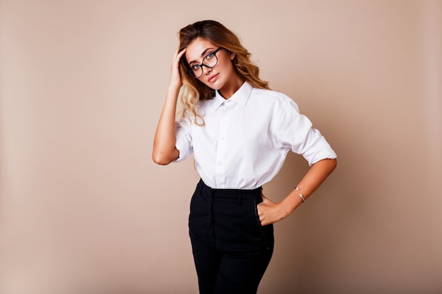 Attractive successful business woman with candid smile looking. Teacher or employe. Beige wall.