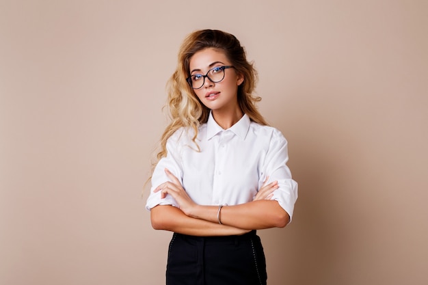 Attractive successful business woman with candid smile looking. Teacher or employe. Beige wall.