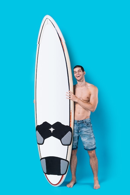 Foto gratuita surfista attraente che tiene una tavola da surf