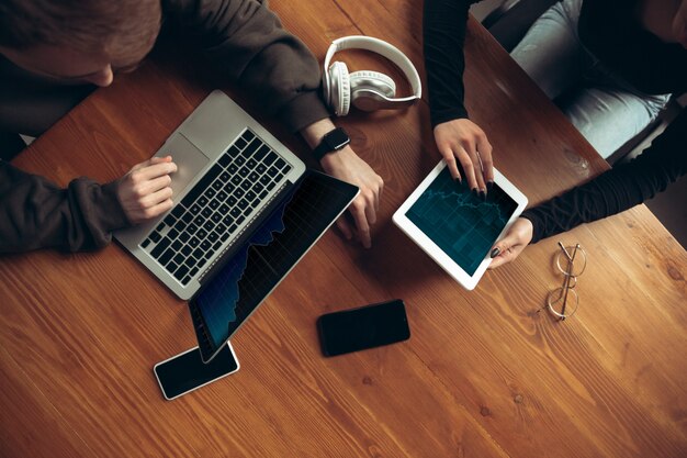 Attractive surprised and amazed couple using devices together