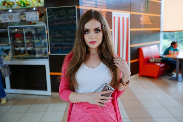 Free photo attractive teenage girl posing with mobile in her hand